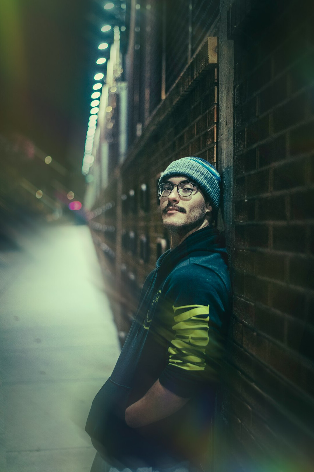 Portrait of a man leaning against a brick wall
