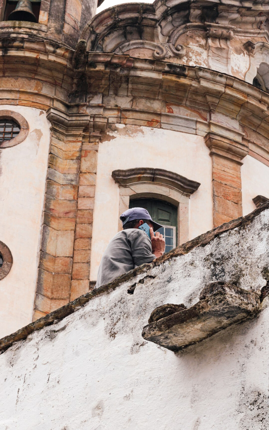 Photographer writing notes beside a camera and old building