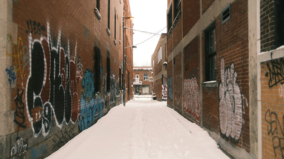 Snow covered alley with fire escapes and graffiti