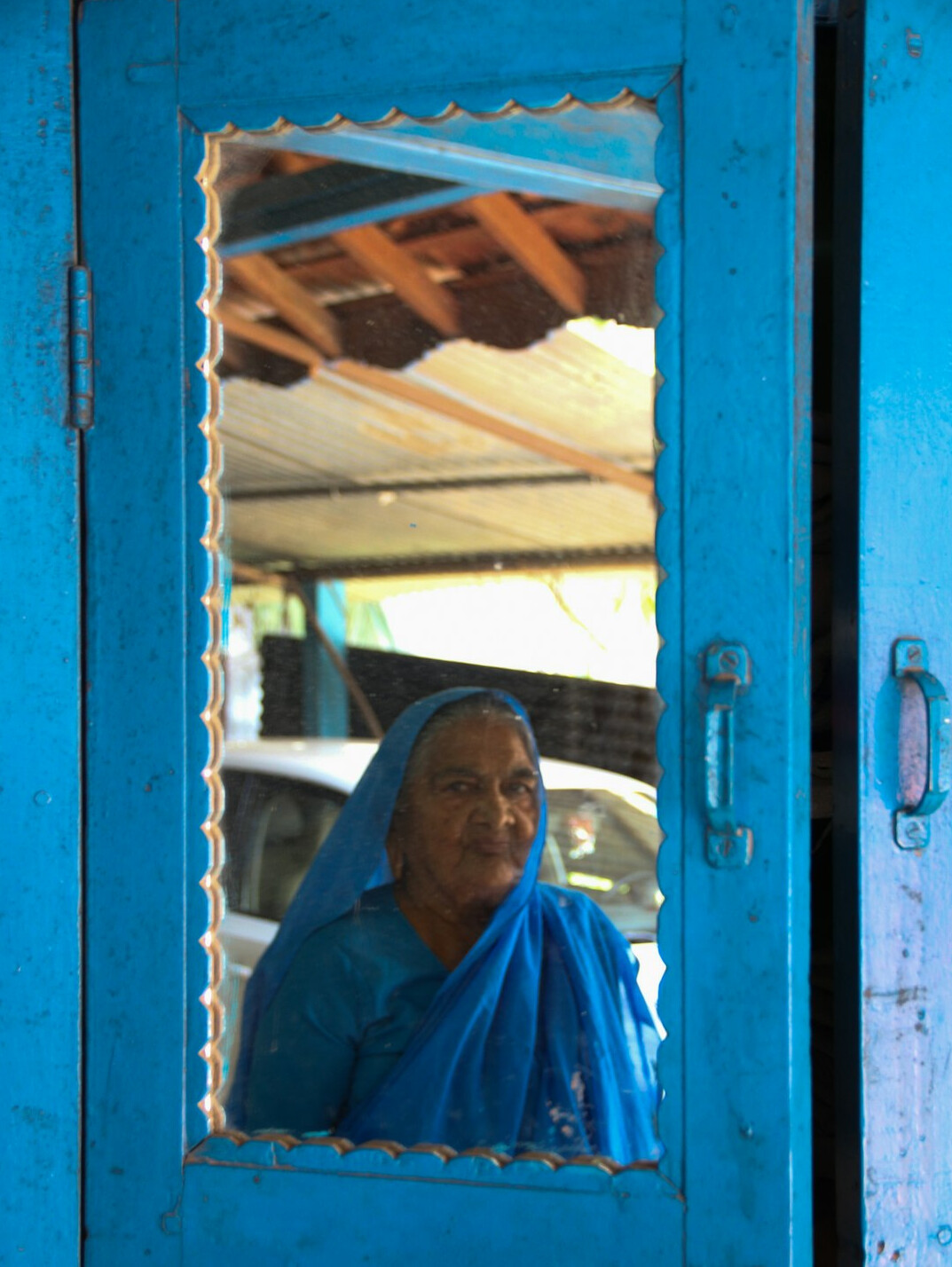 Portrait of an elderly woman standing in a doorway